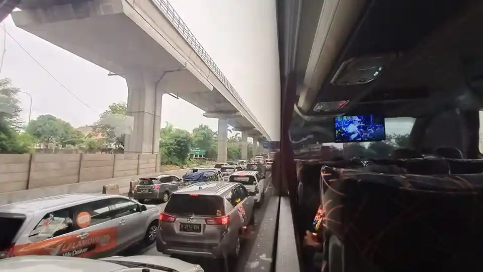 Foto - Tol Jakarta-Cikampek Kebanjiran, Bus AKAP Terjebak Macet di Jalan Raya Kalimalang