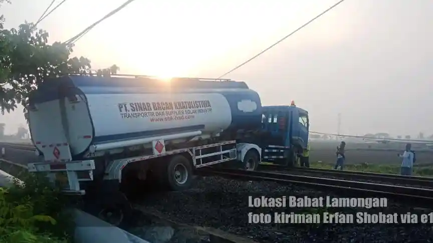 Foto - Ajaib! Hindari Kendaraan Lain, Truk Tangki Isuzu Giga Ini 'Lompat' ke Jalur Rel Kereta Api