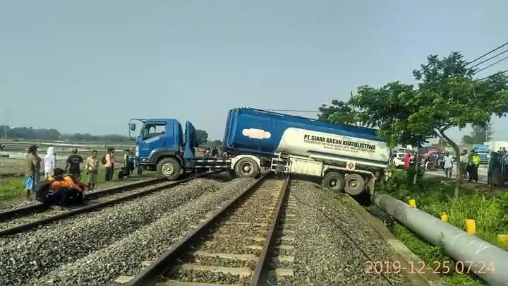 Berita - Ajaib! Hindari Kendaraan Lain, Truk Tangki Isuzu Giga Ini 'Lompat' ke Jalur Rel Kereta Api